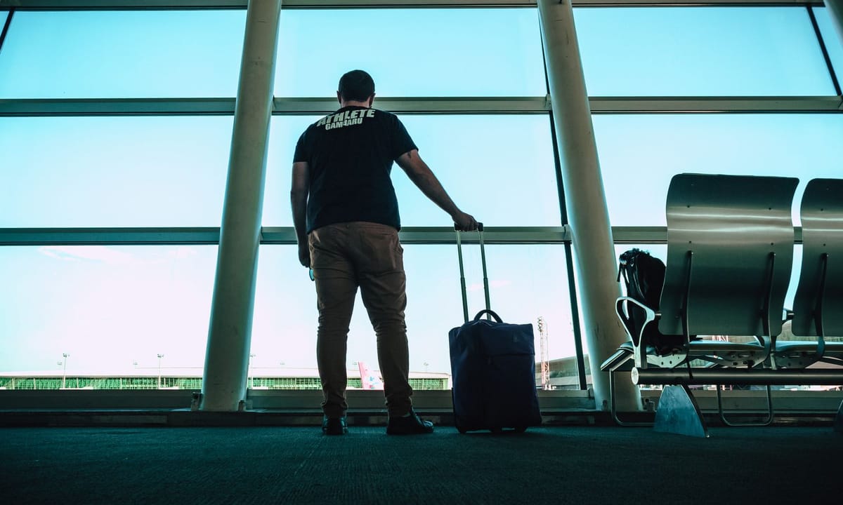 Backpacker with carry-on luggage at airport departure gates