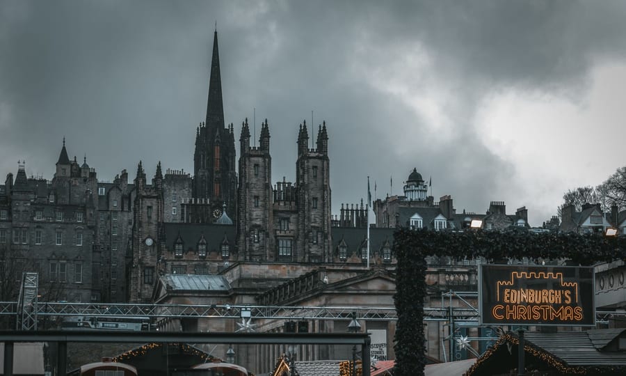 Edinburgh's Christmas sign in Princes Street Gardens below the Old Town skyline under a stormy sky