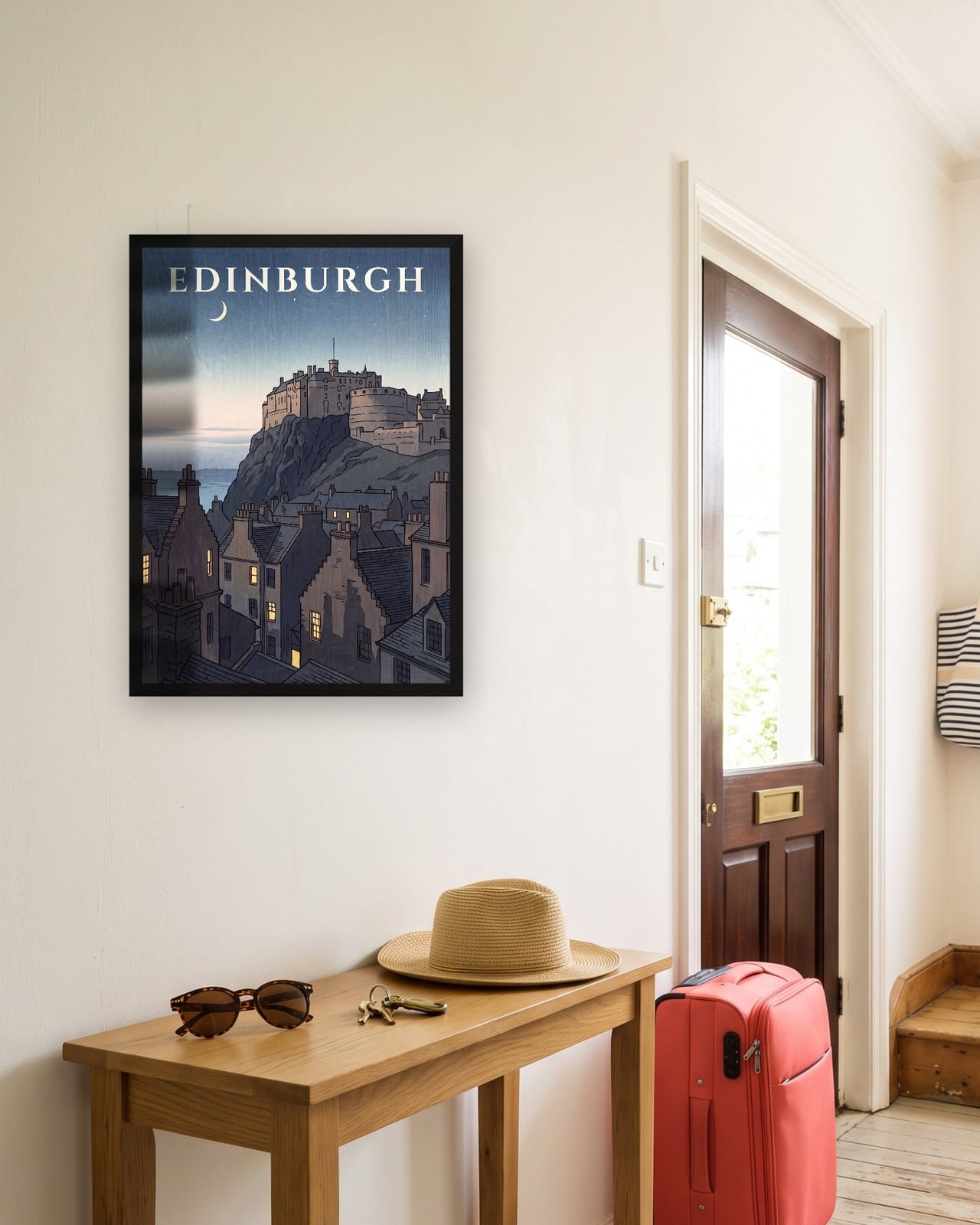 Edinburgh Castle at Dusk print, black frame A3 in a sunny hallway with a packed suitcase