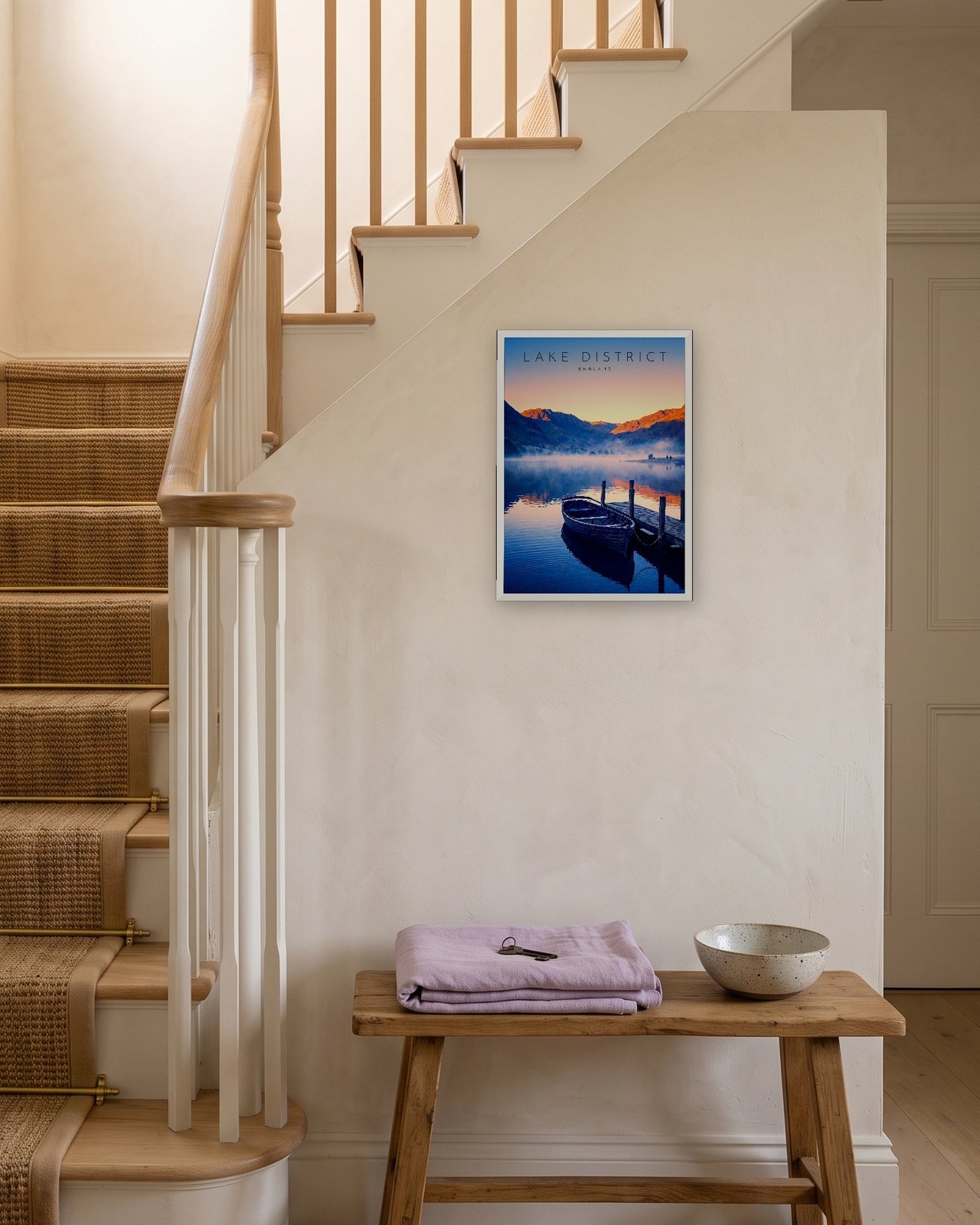 Derwentwater at Dawn print, white frame A3 on a staircase wall