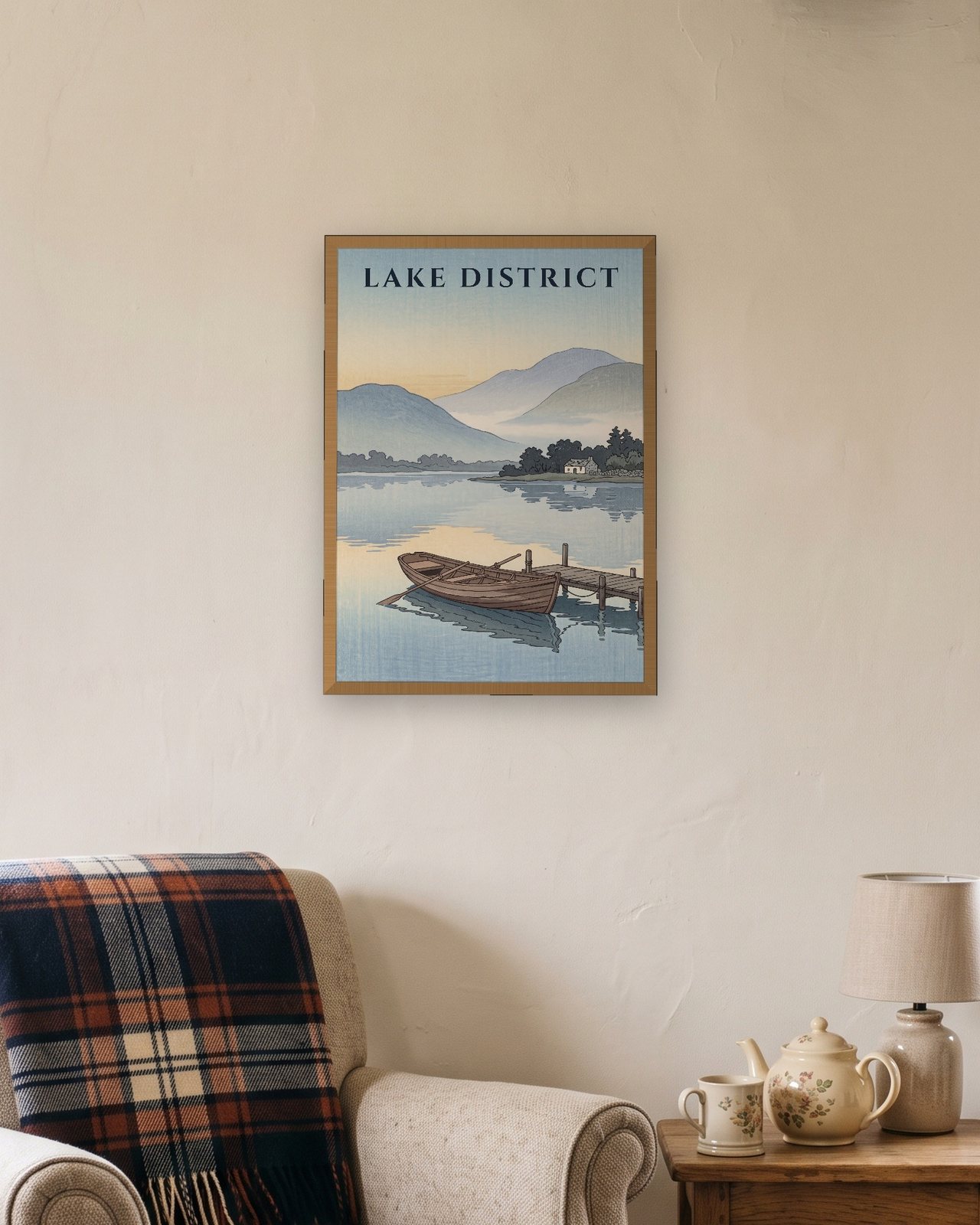 Lake District Rowing Boat print in an oak frame above an armchair with a tartan throw and a teapot