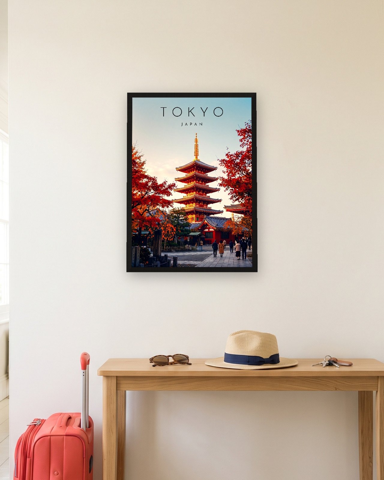 Tokyo Pagoda in Autumn print, black frame A3 in a hallway with a packed suitcase