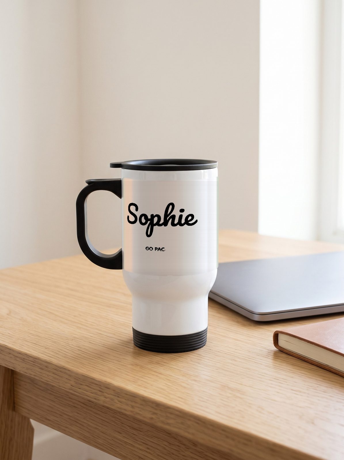 Personalised white steel travel mug with Sophie in black script and the small GO PAC mark, on a desk