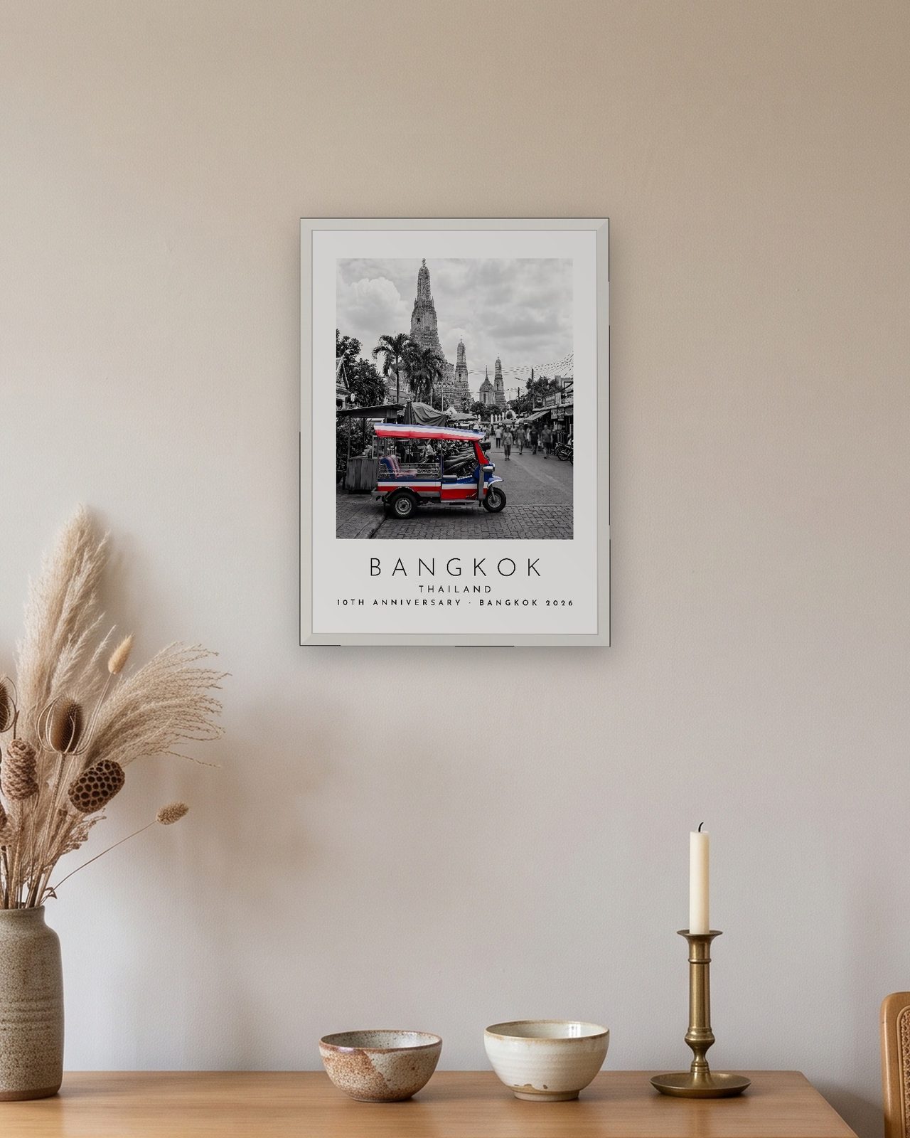 Our Trip Bangkok print: white frame A3 above an oak sideboard, personalised 10TH ANNIVERSARY · BANGKOK 2026