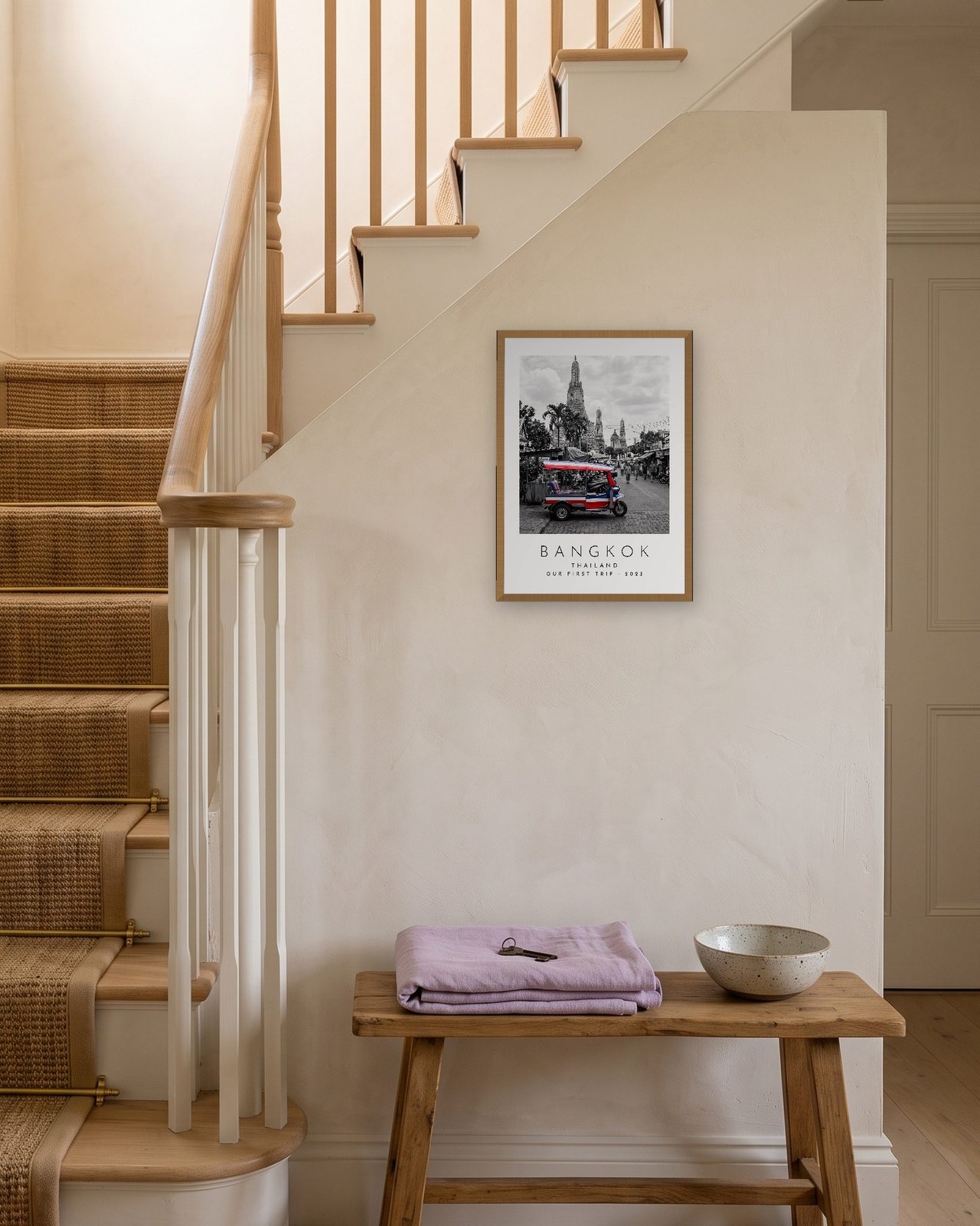 Our Trip Bangkok print: natural oak frame A3 on a staircase wall, personalised OUR FIRST TRIP · 2023