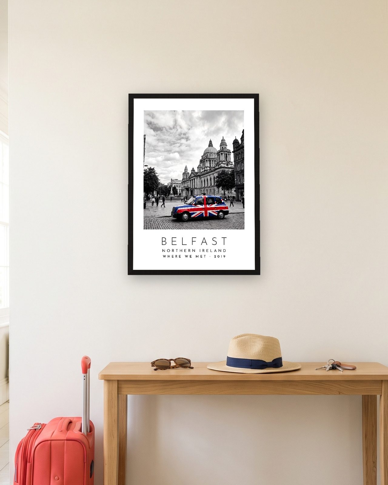 Our Trip Belfast print: black frame A3 in a hallway with a packed suitcase, personalised WHERE WE MET · 2019