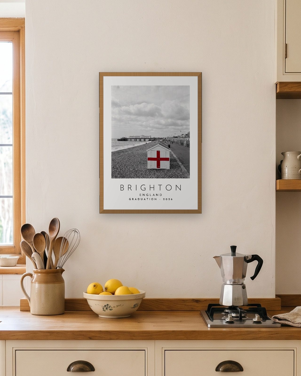 Our Trip Brighton print: natural oak frame A3 in a bright kitchen, personalised GRADUATION · 2026
