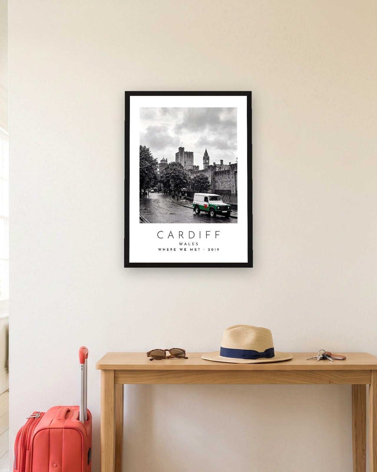 Our Trip Cardiff print: black frame A3 in a hallway with a packed suitcase, personalised WHERE WE MET · 2019