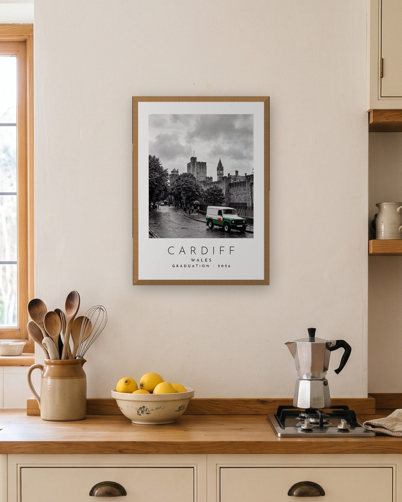 Our Trip Cardiff print: natural oak frame A3 in a bright kitchen, personalised GRADUATION · 2026