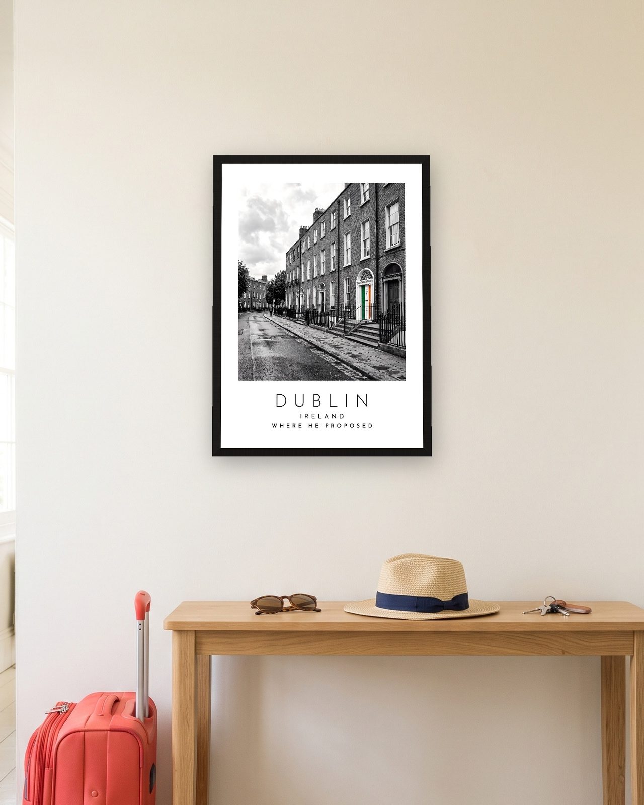 Our Trip Dublin print: black frame A3 in a hallway with a packed suitcase, personalised WHERE HE PROPOSED