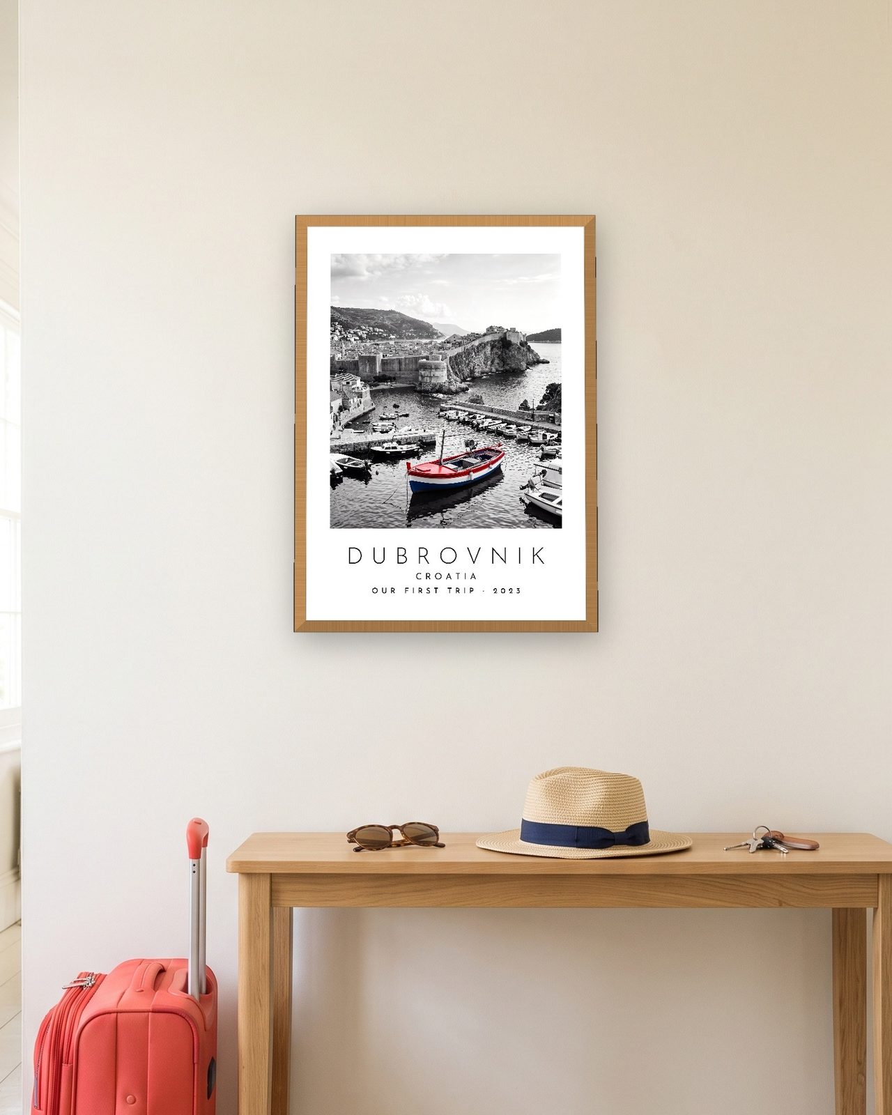 Our Trip Dubrovnik print: natural oak frame A3 in a hallway with a packed suitcase, personalised OUR FIRST TRIP · 2023