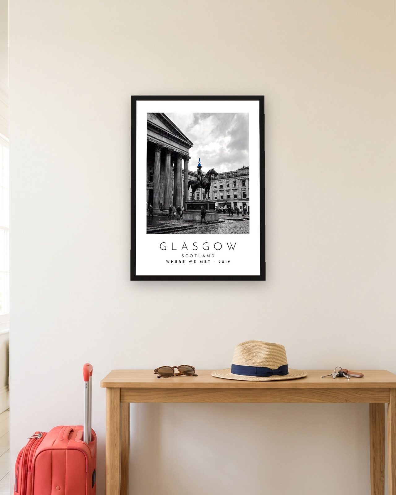 Our Trip Glasgow print: black frame A3 in a hallway with a packed suitcase, personalised WHERE WE MET · 2019