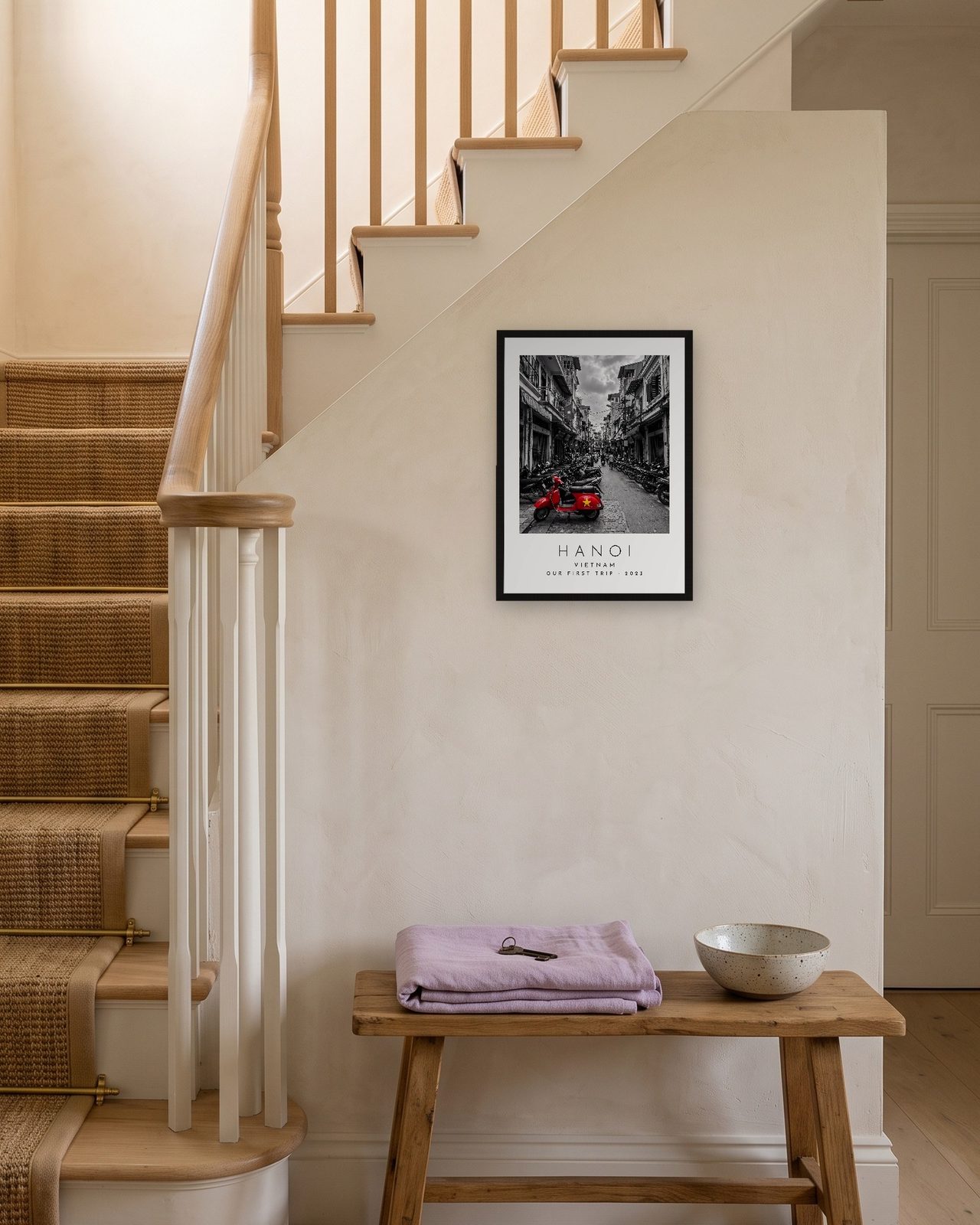 Our Trip Hanoi print: black frame A3 on a staircase wall, personalised OUR FIRST TRIP · 2023
