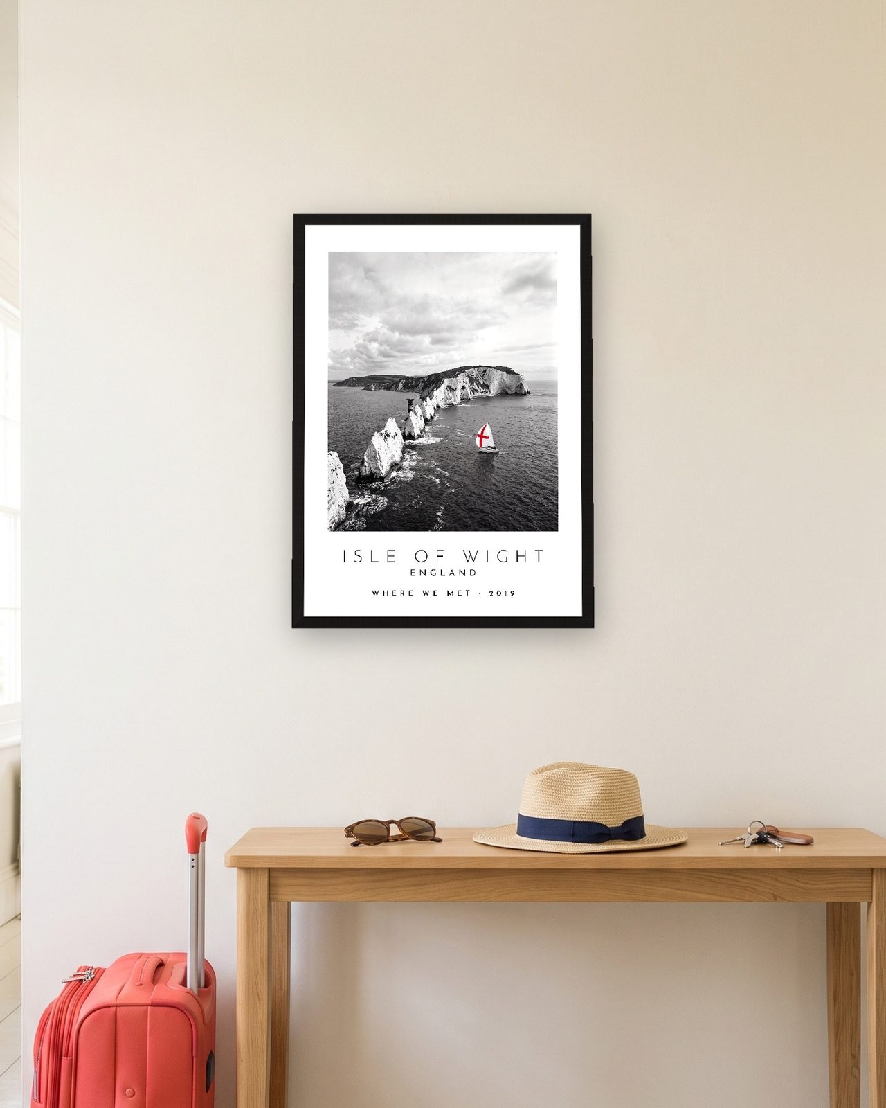 Our Trip Isle of Wight print: black frame A3 in a hallway with a packed suitcase, personalised WHERE WE MET · 2019