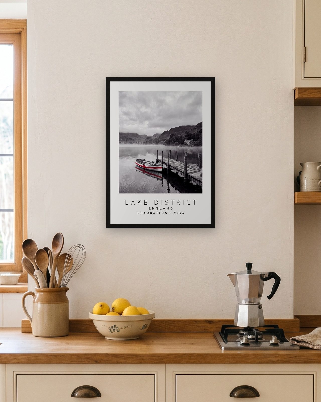 Our Trip Lake District print: black frame A3 in a bright kitchen, personalised GRADUATION · 2026