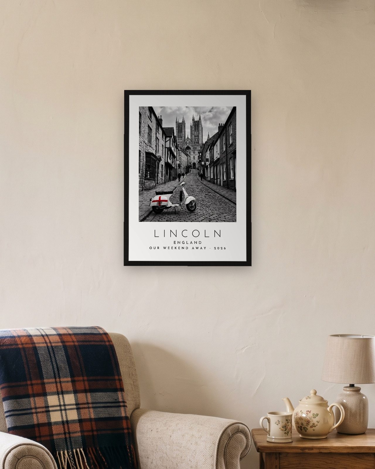 Our Trip Lincoln print: black frame A3 in a cottage snug, personalised OUR WEEKEND AWAY · 2026