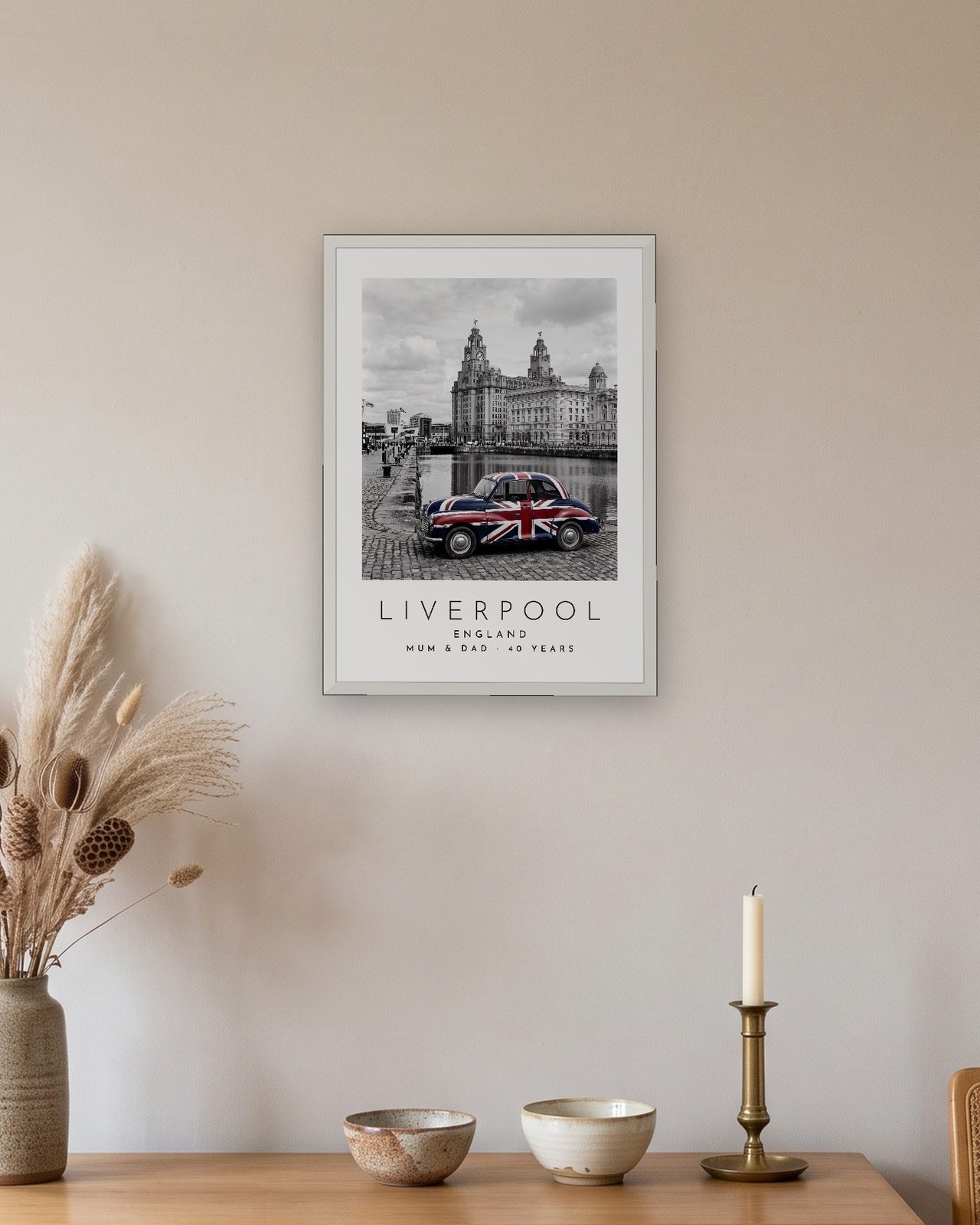 Our Trip Liverpool print: white frame A3 above an oak sideboard, personalised MUM & DAD · 40 YEARS