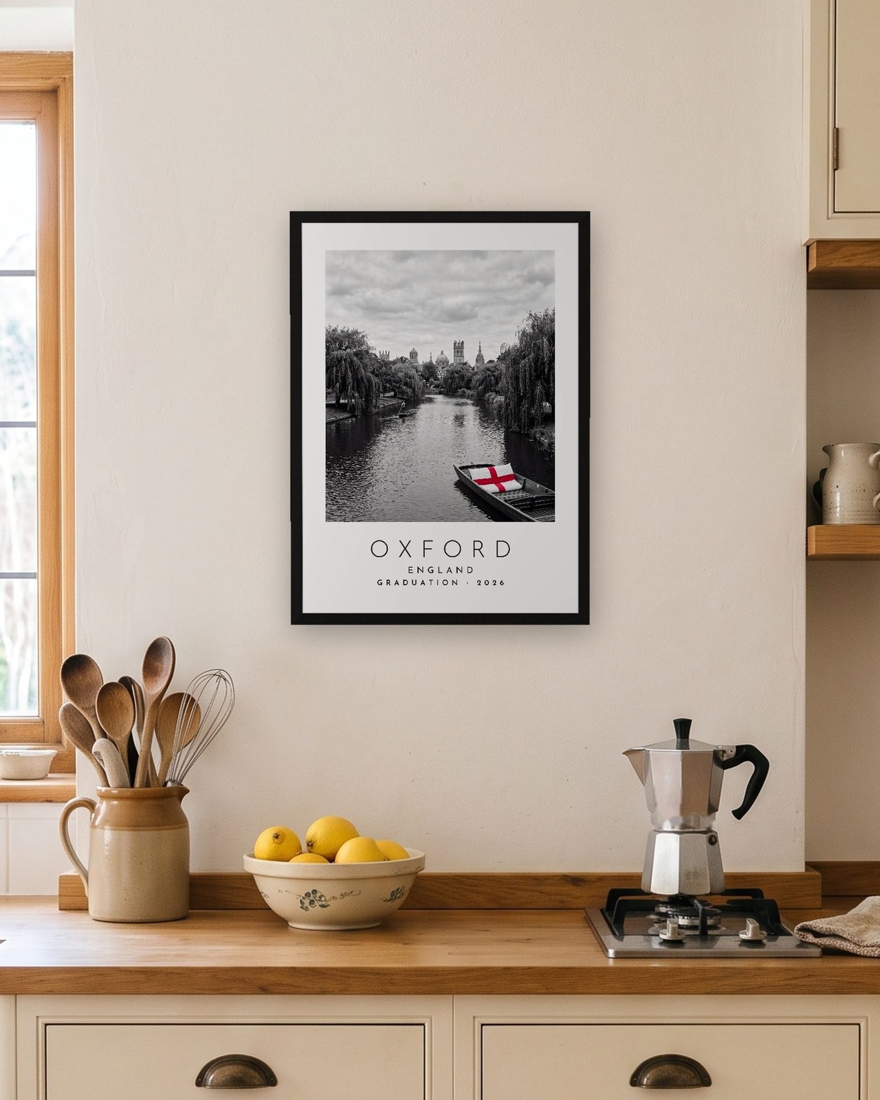 Our Trip Oxford print: black frame A3 in a bright kitchen, personalised GRADUATION · 2026