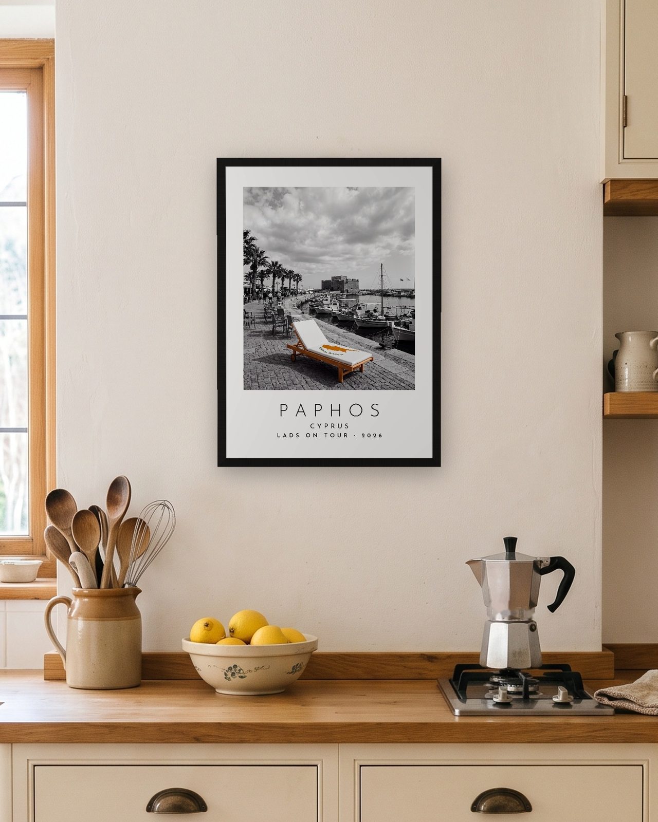 Our Trip Paphos print: black frame A3 in a bright kitchen, personalised LADS ON TOUR · 2026