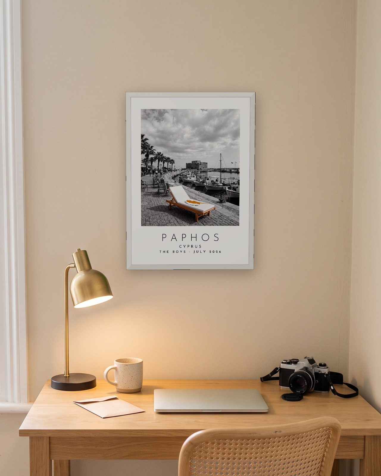 Our Trip Paphos print: white frame A3 above a home office desk, personalised THE BOYS · JULY 2026