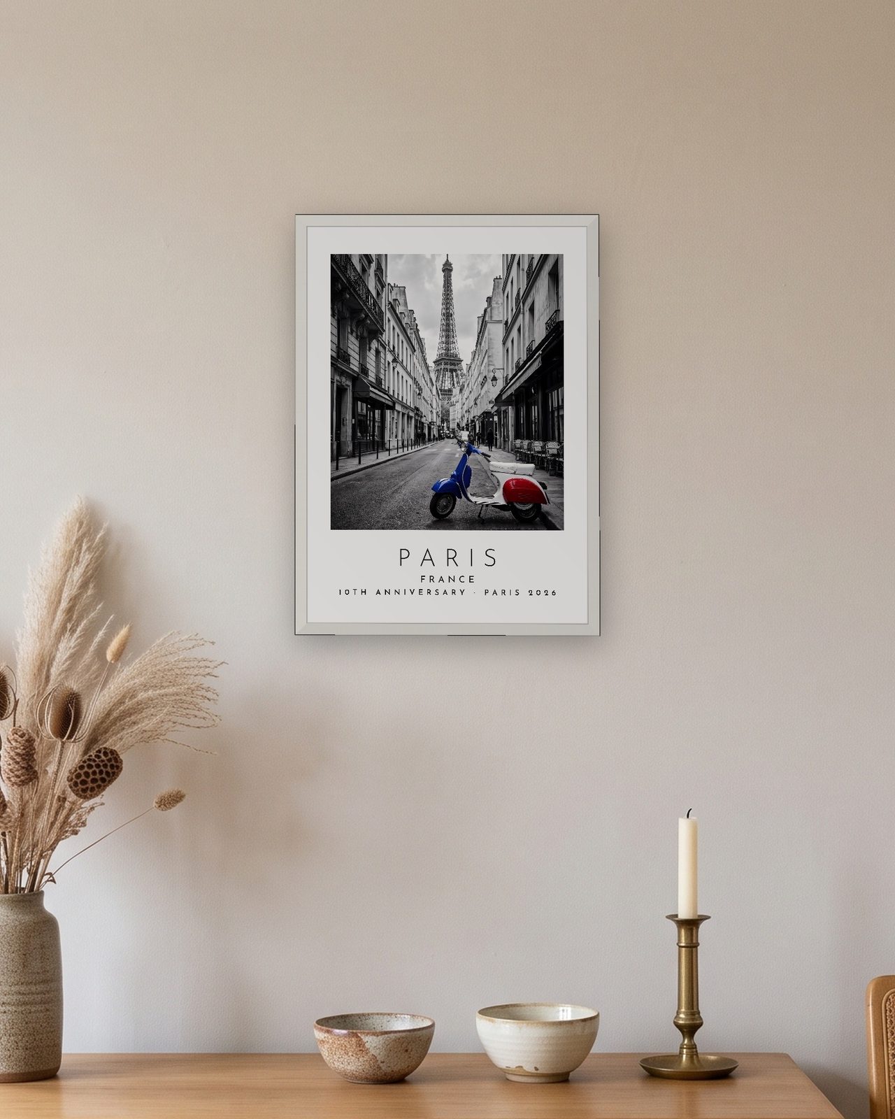 Our Trip Paris print: white frame A3 above an oak sideboard, personalised 10TH ANNIVERSARY · PARIS 2026
