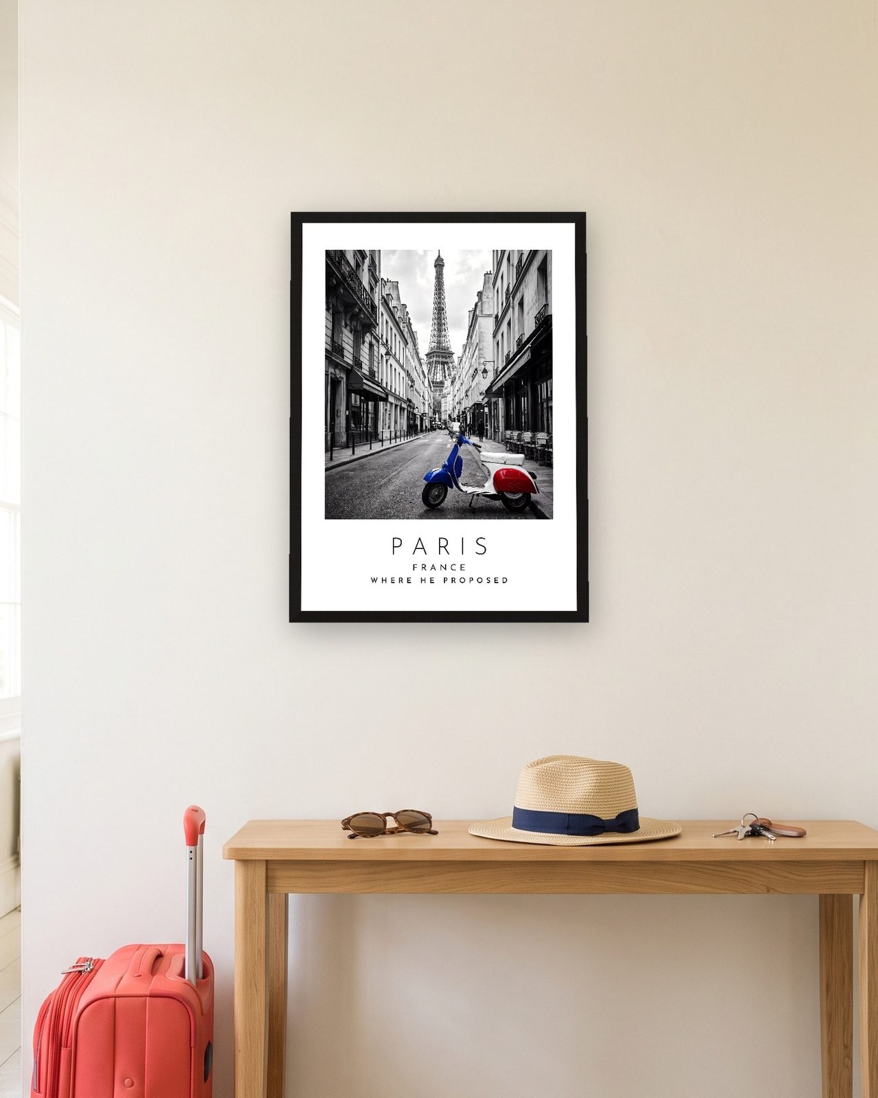 Our Trip Paris print: black frame A3 in a hallway with a packed suitcase, personalised WHERE HE PROPOSED
