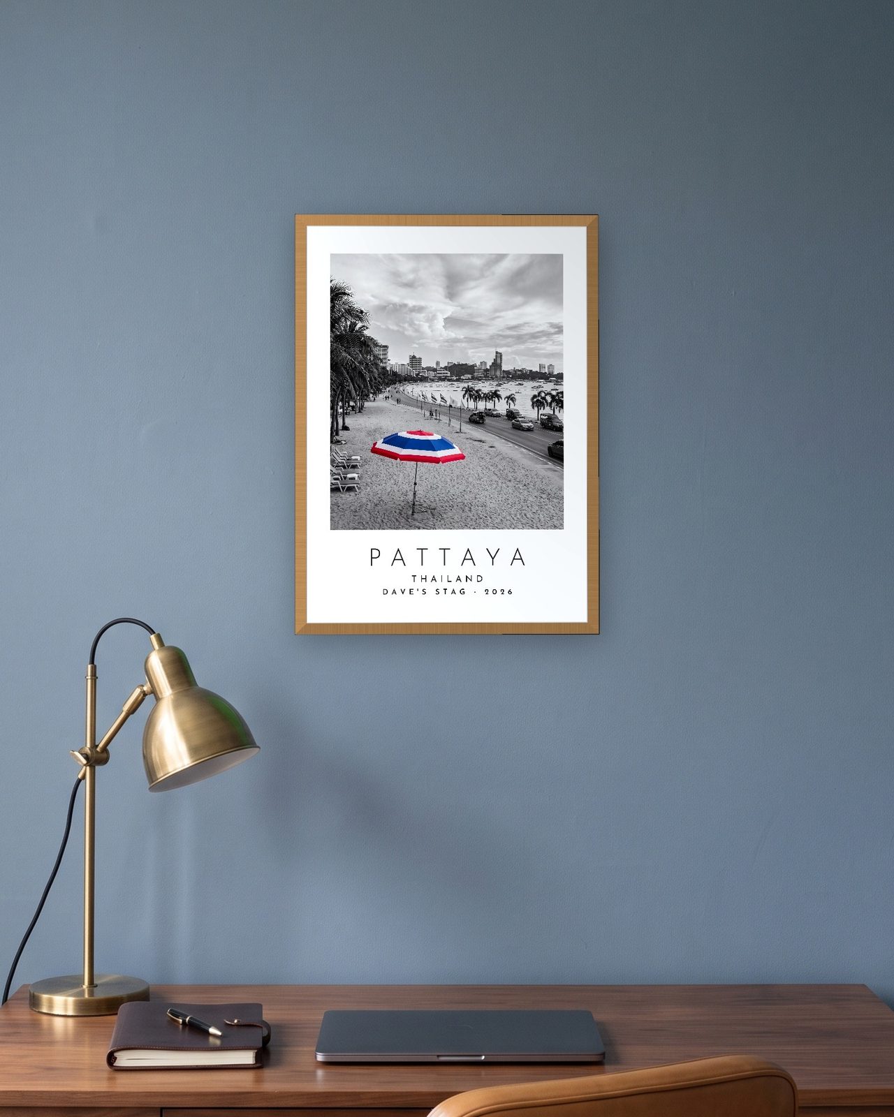 Our Trip Pattaya print: natural oak frame A3 in a slate-blue study, personalised DAVE'S STAG · 2026