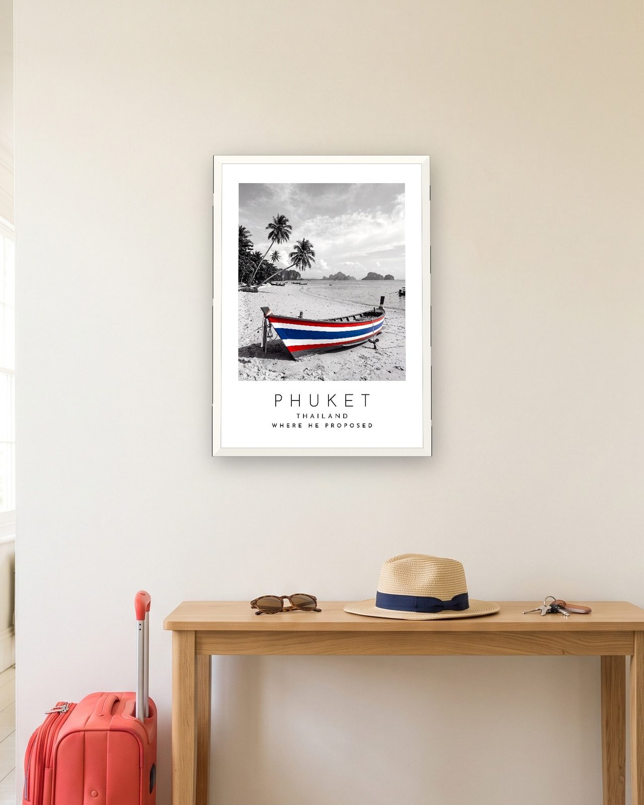 Our Trip Phuket print: white frame A3 in a hallway with a packed suitcase, personalised WHERE HE PROPOSED