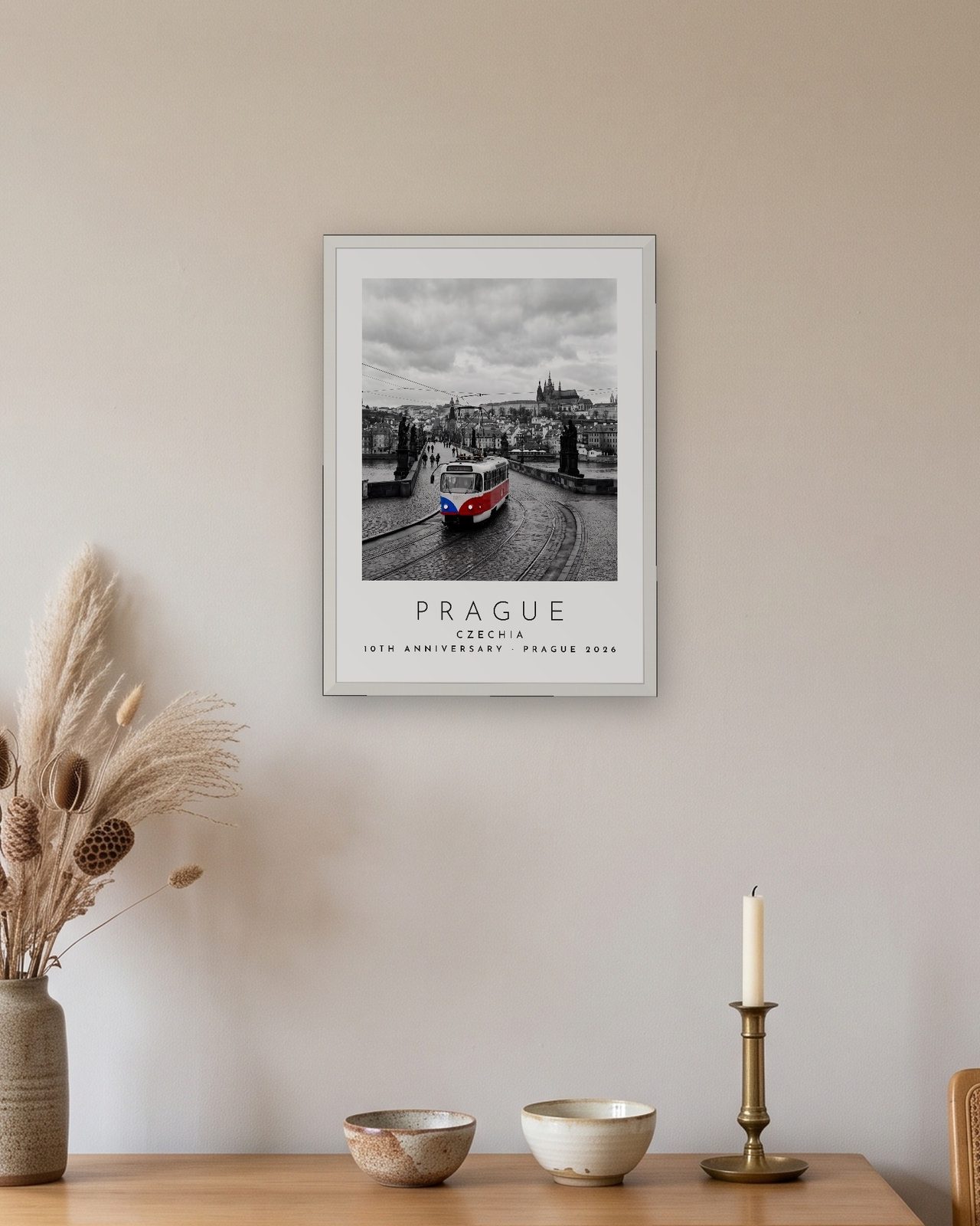 Our Trip Prague print: white frame A3 above an oak sideboard, personalised 10TH ANNIVERSARY · PRAGUE 2026