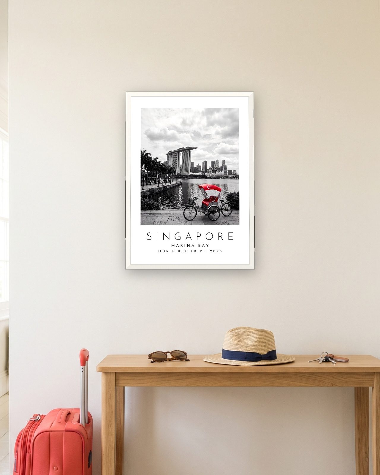 Our Trip Singapore print: white frame A3 in a hallway with a packed suitcase, personalised OUR FIRST TRIP · 2023