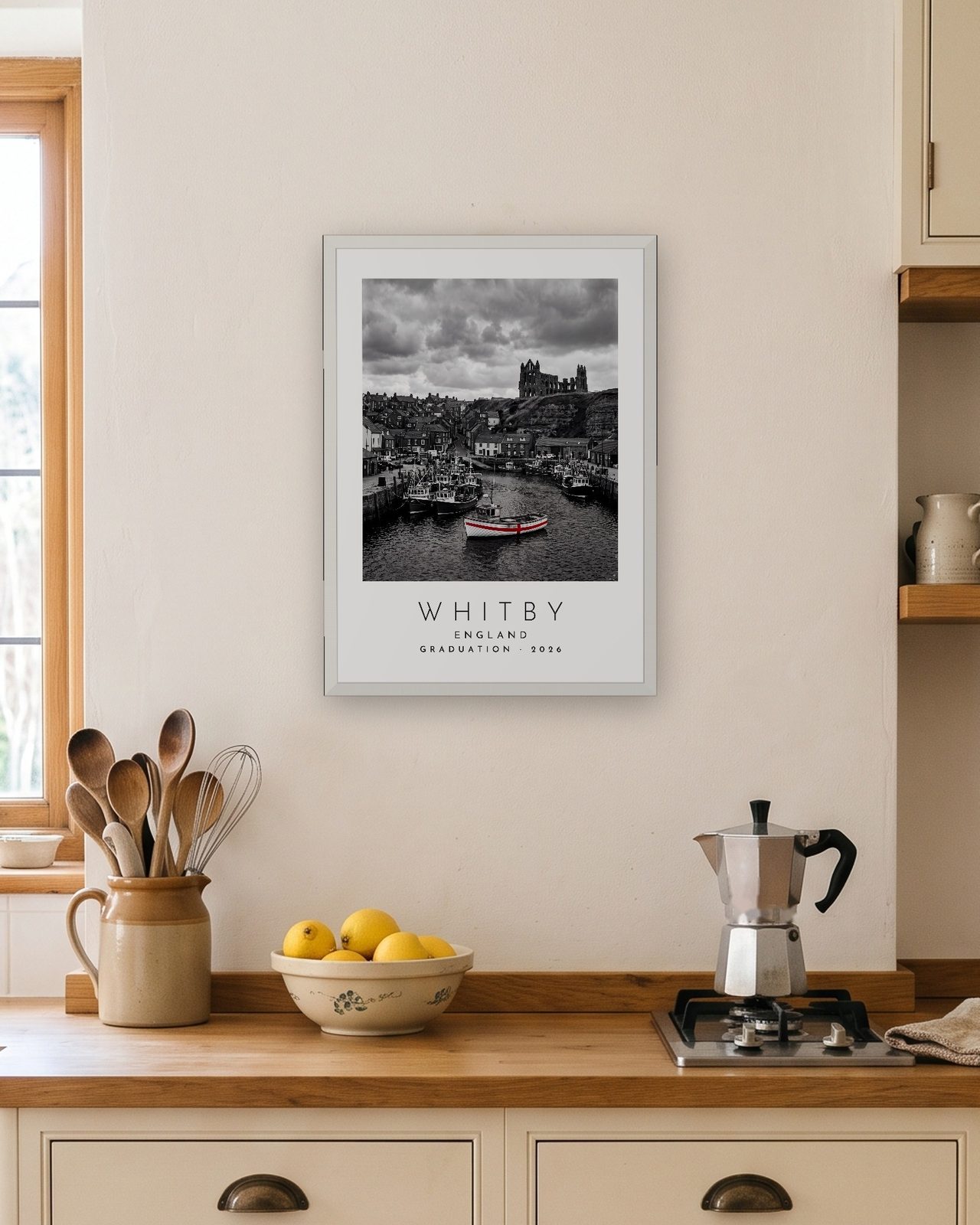 Our Trip Whitby print: white frame A3 in a bright kitchen, personalised GRADUATION · 2026