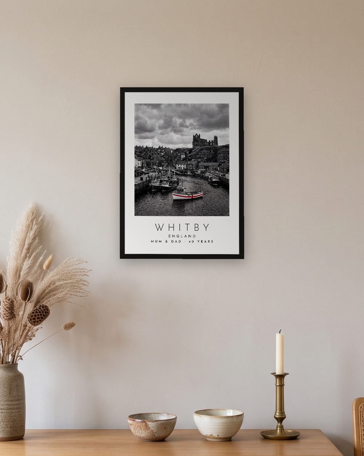 Our Trip Whitby print: black frame A3 above an oak sideboard, personalised MUM & DAD · 40 YEARS
